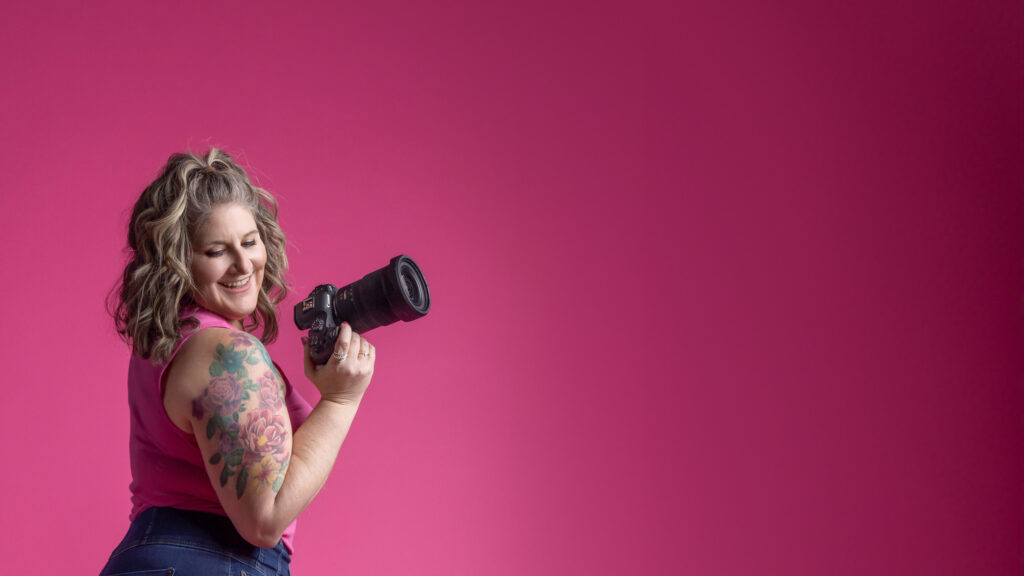 Jennifer Blackburn holding her camera in a well lit studio