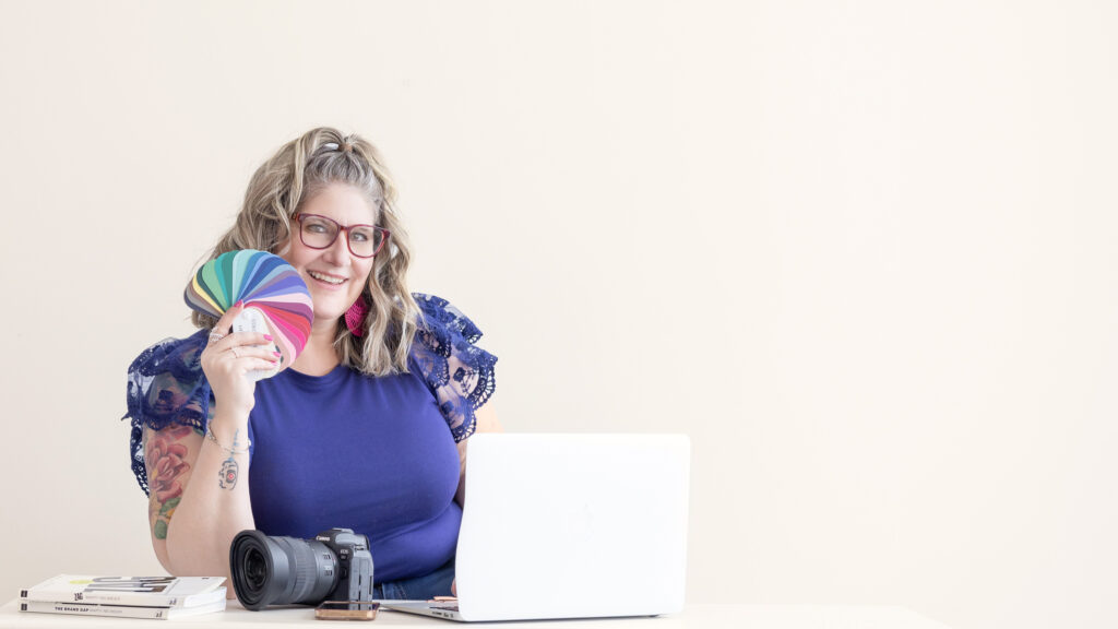 Me sitting at my desk with my laptop, camera, and color wheel